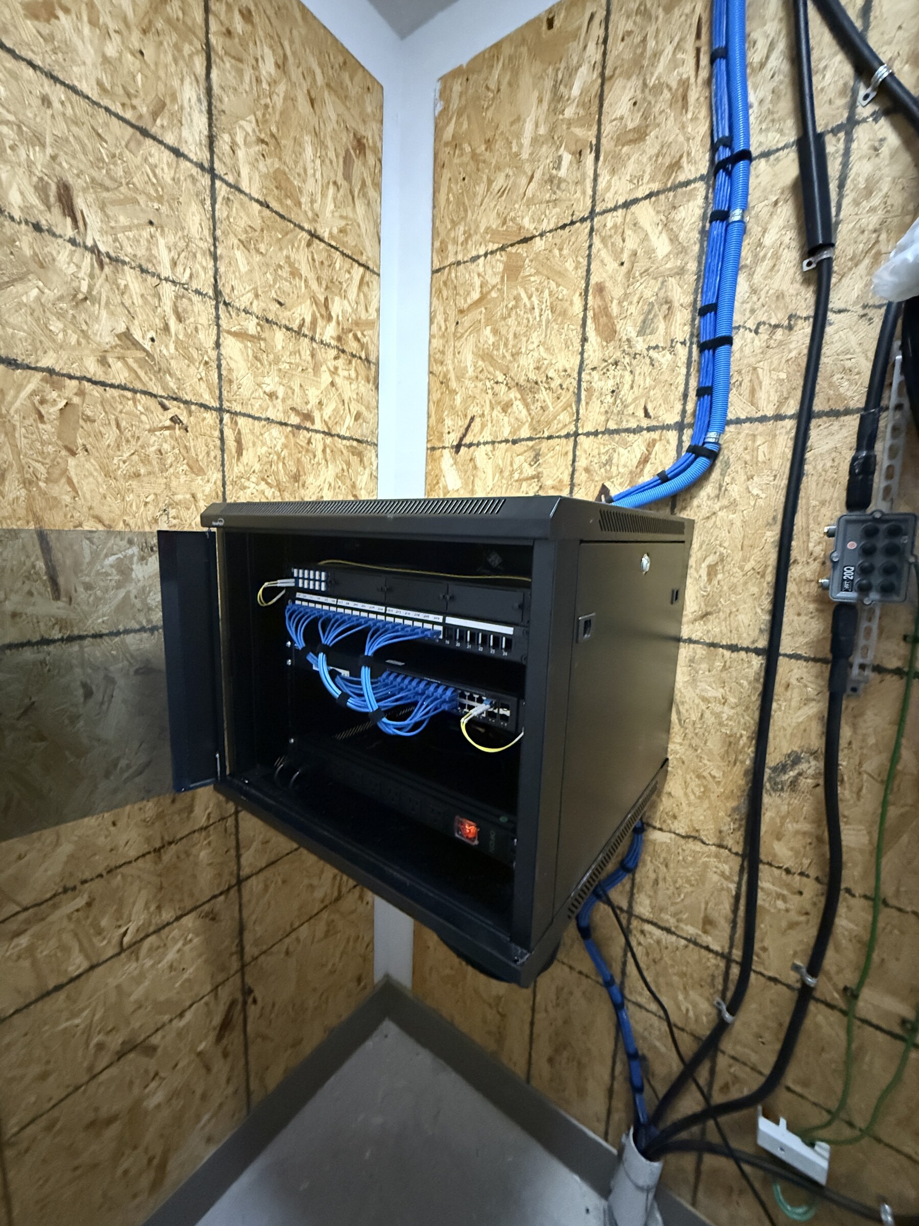 Wall-mounted IDF cabinet with routed common-area pathways and network equipment