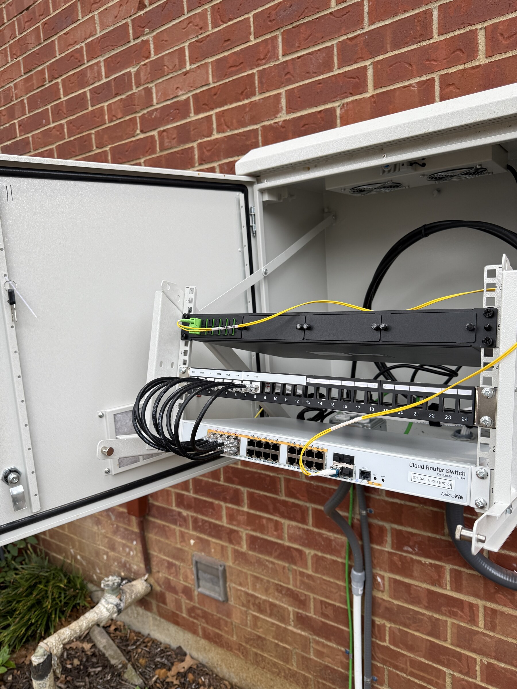 Fiber termination, patching, and network equipment installed inside an exterior IDF enclosure